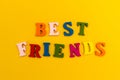 Multicolored letters on a yellow background. Best friends