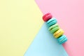 Multicolored macaroons on pastel geometric background.