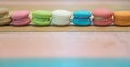 Multicolored macaroons on white wooden background