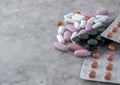 Multicolored medical pills and packs of pills on a table