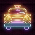 Multicolored neon sign car taxi, front view. Against the background of a brick wall with a shadow.