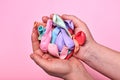 Multicolored not inflated balloons in the hands of a woman on a pink background Royalty Free Stock Photo