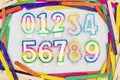 Multicolored numerical numbers set from zero to nine 0123456789 shape candles in a colorful sticks frame border on white Royalty Free Stock Photo