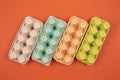 Multicolored organic egg trays on orange background with copyspace for your text. Biodegradable and compostable paper Royalty Free Stock Photo