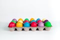 Colorful Easter eggs in cardboard box on white background.