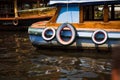 Multicolored painted old car tires hang over the side of a pleasure boat. Royalty Free Stock Photo