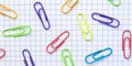 Multicolored paper clips on the blank checkered page.