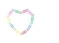 Multicolored paper clips with love sign heart shape on white background. Decorative paper clips in pink, yellow, green, red and Royalty Free Stock Photo