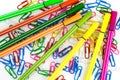 multicolored paper clips and markers randomly scattered on white paper Royalty Free Stock Photo