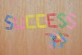 Multicolored of paper clips taken concatenation is the message that `SUCCESS`