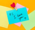 paper notes with text ps i love you with cloth pin decorated with red heart