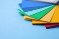 Multicolored paper sheets on blue background, space for text. Rainbow palette Royalty Free Stock Photo