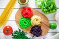 Multicolored pasta on a plate and vegetables isolated on white wood background. Flat lay. Top view. Asian food Royalty Free Stock Photo