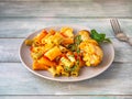 Multicolored pasta with vegetables and basil and fried chicken drumstick on a light ceramic plate Royalty Free Stock Photo