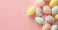 Multicolored pastel decorative eggs on a pink background. Copy space.