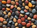 Multicolored pebbles, marble stones seamless pattern isolated on black background