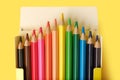 Multicolored pencils in a box isolated on yellow Royalty Free Stock Photo