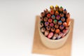 Multicolored pencils in the box on the white paper. Royalty Free Stock Photo