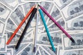Multicolored pencils on money banknotes