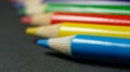 Multicolored pencils in a row on a black background. Concepts of diversity and variety. Royalty Free Stock Photo