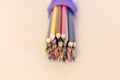 Multicolored pencils on the table. A stack of colored pencils tied together. A scattering of writing supplies and stationery. Royalty Free Stock Photo