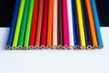 Multicolored pencils on a white and black background Royalty Free Stock Photo