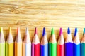 Multicolored pencils on wooden background forming a pattern with Royalty Free Stock Photo