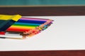 Multicolored pensils in the box on a wooden table. Royalty Free Stock Photo