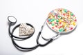 Multicolored pills decorative heart and stethoscope on a white background. Royalty Free Stock Photo