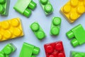 Multicolored plastic kids constructor on blue background. Colored children's bricks for construction. Flat lay top view