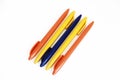 Multicolored plastic stationery pens on a white background