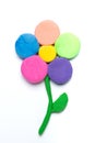 Multicolored plasticine flower on white background, children`s creativity