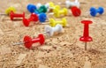 Multicolored push pins on a wooden table. Royalty Free Stock Photo