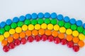 Multicolored rainbow made of round colored dragee sweets lies on a white background Royalty Free Stock Photo