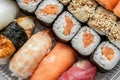 Multicolored rolls and sushi rice, caviar and salmon, eel, trout on the table in the background. Royalty Free Stock Photo