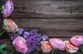 Multicolored roses and a branch of lilac on a wooden surface.Top view.Copy space Royalty Free Stock Photo