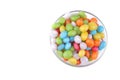 Multicolored round candy in a glass bowl on a white background. Isolated.