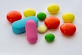 Multicolored round and oval tablets and pills close-up on a white background. Royalty Free Stock Photo