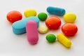 Multicolored round and oval tablets and pills close-up on a white background. Royalty Free Stock Photo