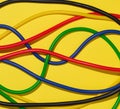Multicolored rubber tubes on a yellow background, top view