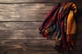 a multicolored scarf on a wooden surface with a wooden background that looks like a wood planks pattern, with a red, yellow, Royalty Free Stock Photo