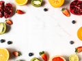 Multicolored seasonal healthy natural fruit frame with persimmon, blueberries, orange, kiwi, strawberries, grapefruit, pomegranate