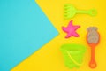 Multicolored set children`s toys for summer games in sandbox or on sandy beach on blue yellow background with copy space. Top vie Royalty Free Stock Photo