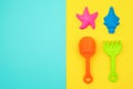 Multicolored set children`s toys for summer games in sandbox or on sandy beach on blue yellow background with copy space. Top vie Royalty Free Stock Photo