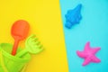 Multicolored set children`s toys for summer games in sandbox or on sandy beach on blue yellow background with copy space. Top vie Royalty Free Stock Photo