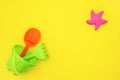 Multicolored set children`s toys for summer games in sandbox or on sandy beach on yellow background with copy space. Top view Fla Royalty Free Stock Photo