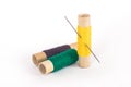 Multicolored sewing spools with threads and needle on white background Royalty Free Stock Photo