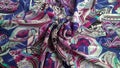 Multicolored silk fabric with abstract wonderful pattern is laid out beautifully.