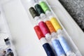 Multicolored skeins of thread in the set. Threads and a thimble in a plastic box Royalty Free Stock Photo