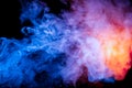 Multicolored smoke like cosmic dust of blue, red, magenta and fiery orange on a black is wrapped in rings Royalty Free Stock Photo